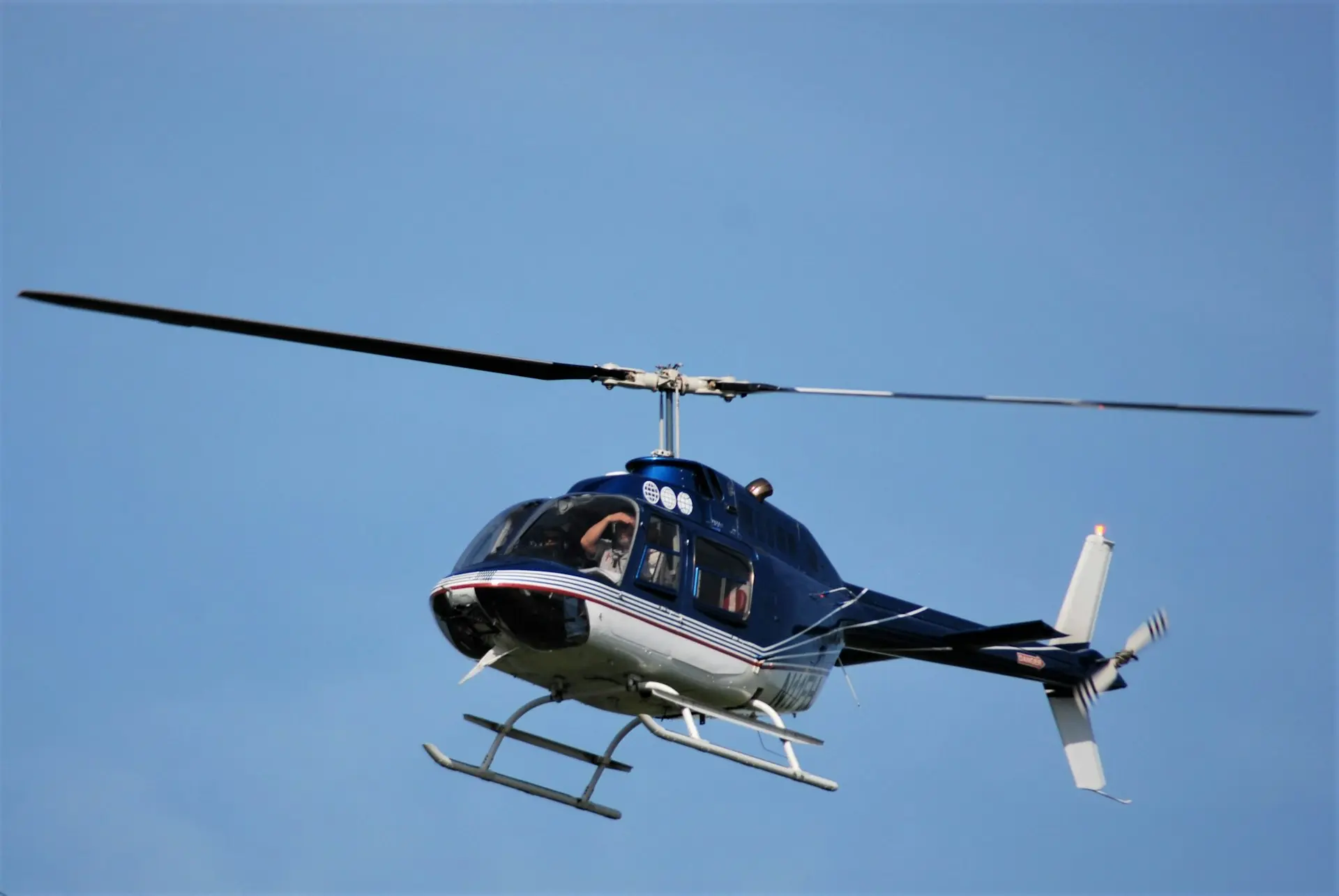 blue and white helicopter flying in the sky during daytime